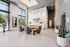Elegant apartment lobby with modern decor, featuring stylish seating area, chic lighting, and large windows overlooking greenery.