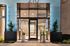 Chic apartment entrance featuring sleek glass doors, modern lighting, and stylish planters, offering a warm and inviting welcome.