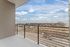 Inviting balcony with modern railing offering panoramic views of the cityscape and open skies, perfect for relaxation.