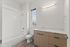 Modern bathroom with elegant cabinetry, a spacious bathtub, and a bright window view.