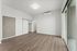 Bright and spacious modern room with elegant wood flooring, stylish barn door, and large sliding glass window for natural light.