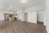 Sleek open-concept kitchen and living area with modern stainless steel appliances and elegant wood flooring.