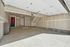 Spacious and clean garage interior with ample storage, featuring high ceilings and convenient access door.