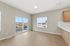Bright and airy living space with large windows offering stunning views, complemented by sleek hardwood flooring and modern kitchen cabinetry.