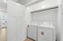Modern laundry area with washer and dryer in a sleek, minimalistic apartment setting.