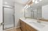 Modern bathroom with a sleek double vanity, polished fixtures, and a spacious glass-enclosed shower.