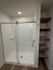 Modern bathroom featuring a sleek glass-enclosed shower with elegant shelving, ideal for stylish and efficient storage.