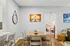 Cozy dining area with modern decor, featuring a stylish circular mirror and vibrant artwork, adjacent to a colorful bedroom.
