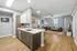 Spacious open-concept living area showcasing a modern kitchen with sleek cabinetry, flowing seamlessly into a cozy living room with stylish decor and vibrant accents.
