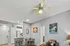 Inviting open-plan living area showcasing modern furniture, colorful artwork, and a sleek kitchen with bar seating.