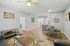 Contemporary living and dining area with stylish decor, featuring elegant wood flooring, modern furnishings, and vibrant wall art.