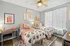 Charming bedroom with twin beds, vibrant decor, and stylish artwork, featuring patterned quilts, a cozy study desk, and light, airy curtains.