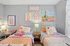 Charming bedroom with twin beds, playful western-themed decor, vibrant pillows, and a cozy study nook.