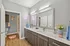 Sleek and modern bathroom with double sinks, elegant cabinetry, and vibrant decor including a playful pink neon wall sign.