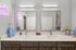 Modern bathroom with dual sinks, sleek mirrors, and ambient lighting, featuring vibrant decor and plush towels.