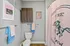 Charming bathroom with stylish decor, featuring a pink shower curtain with a horse design, elegant wall art, and fresh blue towels providing a cozy ambiance.