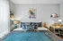 Charming, modern bedroom featuring stylish decor, cozy bedding, vibrant wall art, and a functional study area with natural light.