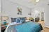 Bright and stylish bedroom with modern decor, cozy bed setup, and inviting desk area featuring trendy artwork and lighting.