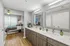 Modern apartment interior showcasing a stylish bathroom with dual sinks and mirrors, elegantly connected to a cozy, well-lit bedroom.