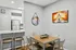 Modern dining area with stylish metal chairs, sleek wooden table, and contemporary art, adjacent to a chic open kitchen with stainless steel appliances.