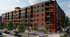 Contemporary apartment building with mixed brick and modern facade, featuring multiple floors and balconies.