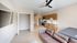 Modern open-concept apartment with sleek kitchen, stylish ceiling fan, and cozy living area. Bright space featuring wood accents and a built-in closet.
