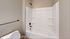 Modern bathroom with a sleek white bathtub and neutral-toned walls, offering a refreshing and minimalistic design.