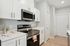 Modern kitchen featuring sleek stainless steel appliances, pristine white cabinetry, and elegant wood flooring | Legacy at Crowley | Atlanta Apartments
