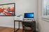 Modern home office corner featuring a sleek desk with a computer and printer, accented by vibrant abstract artwork, perfect for productivity and inspiration. | Legacy at Crowley | Atlanta Apartments
