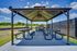 Inviting outdoor pavilion with picnic tables and barbecue grill, perfect for gatherings and relaxation amid lush greenery.