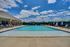 Inviting outdoor swimming pool area with sun loungers and a clear blue sky, perfect for relaxation.