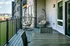 Chic apartment balcony featuring cozy hanging chairs, modern outdoor seating, and a scenic view of lush greenery.