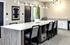 Modern kitchen with sleek white countertops, stylish pendant lighting, and elegant bar seating, perfect for entertaining.