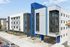 Modern apartment building with sleek design, featuring large windows and stylish blue accents, located in a vibrant urban area.