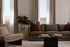 Elegant living room with plush seating, warm neutral tones, and a modern coffee table, featuring soft natural light through large windows.