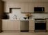 Modern kitchen with sleek beige cabinetry, stainless steel appliances, and elegant marble backsplash, featuring vibrant floral decor.