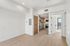 Sleek modern apartment showcasing light wood flooring, a stylish kitchen with stainless steel appliances, and an airy layout leading to a bright balcony.