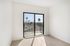 Bright room with elegant wooden flooring and large sliding doors leading to a balcony with scenic palm tree views.