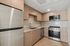 Modern kitchen with sleek stainless steel appliances, elegant wood cabinetry, and a chic marble backsplash.