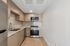 Modern kitchen with sleek cabinetry, stainless steel appliances, and elegant marble countertops in a stylish apartment.