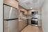 Modern kitchen with sleek stainless steel appliances, elegant wooden cabinetry, and polished marble backsplash.