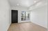 Bright and modern room with light wood flooring, ample natural light from a large window, and sleek minimalist design.