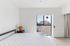 Bright bedroom featuring a minimalist design, large window with a serene view, and elegant decor with wooden accents.