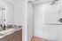 Sleek modern bathroom featuring a spacious walk-in shower and elegant marble countertop with stylish fixtures.