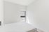Bright and airy bedroom with modern design, featuring a large window and minimalist decor.