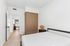 Bright and airy bedroom with sleek wooden wardrobe, modern furnishings, and a glimpse into a sunlit sitting area.