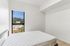 Bright, minimalist bedroom with a large window showcasing a stunning mountain view, enhancing the serene ambiance.