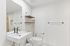 Sleek, modern bathroom featuring a minimalist design with a spacious sink, elegant fixtures, and stylish open shelving.