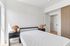 Bright and modern bedroom with minimalist decor, featuring sleek furniture and abundant natural light.