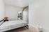 Bright and minimalist bedroom with modern furniture and ample storage.